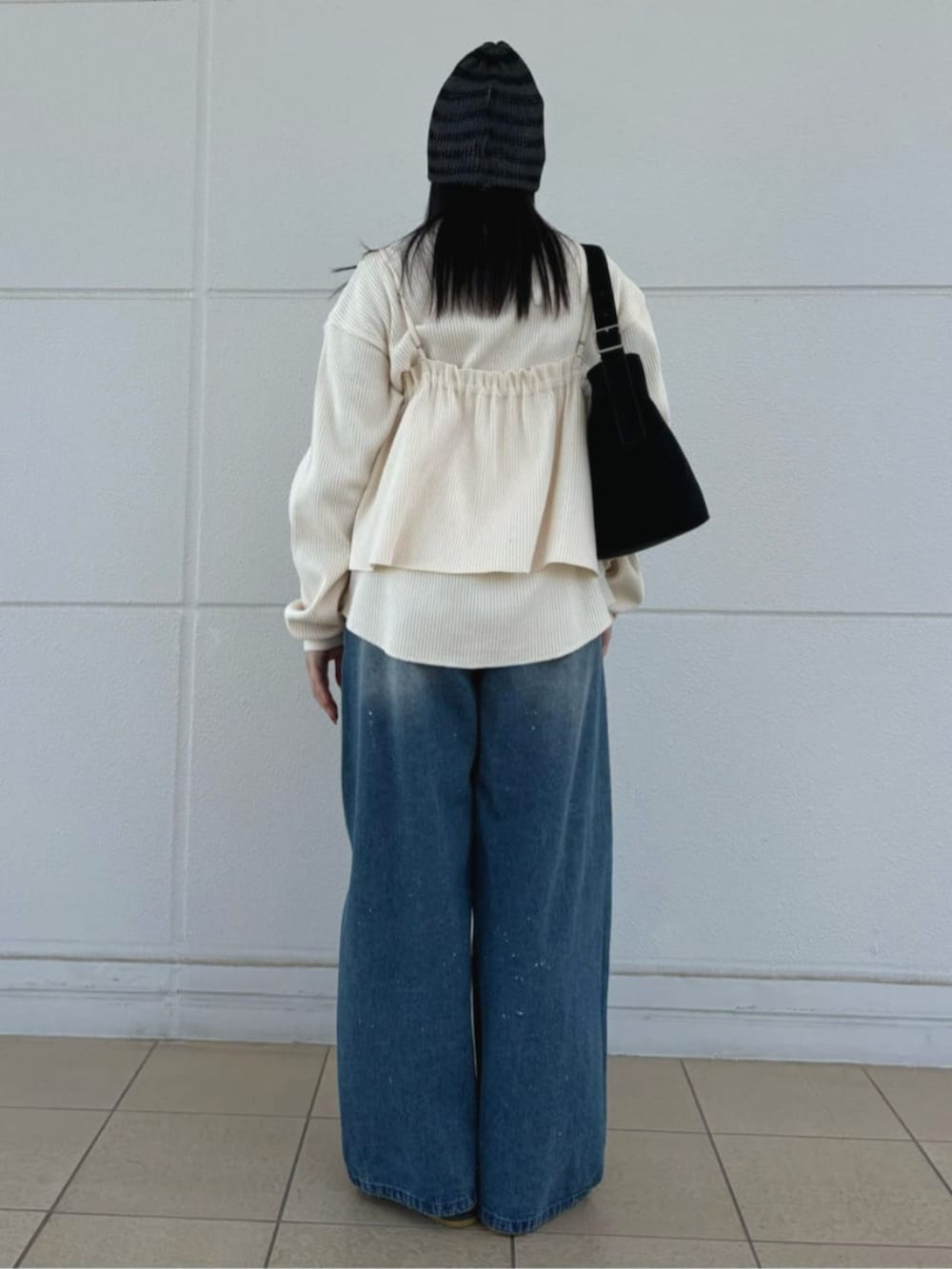 ブラック系のハンドバッグ、ブルー系のデニムパンツ、ホワイト系のTシャツ/カットソーを着用したレディースの春コーディネートの3枚目の写真