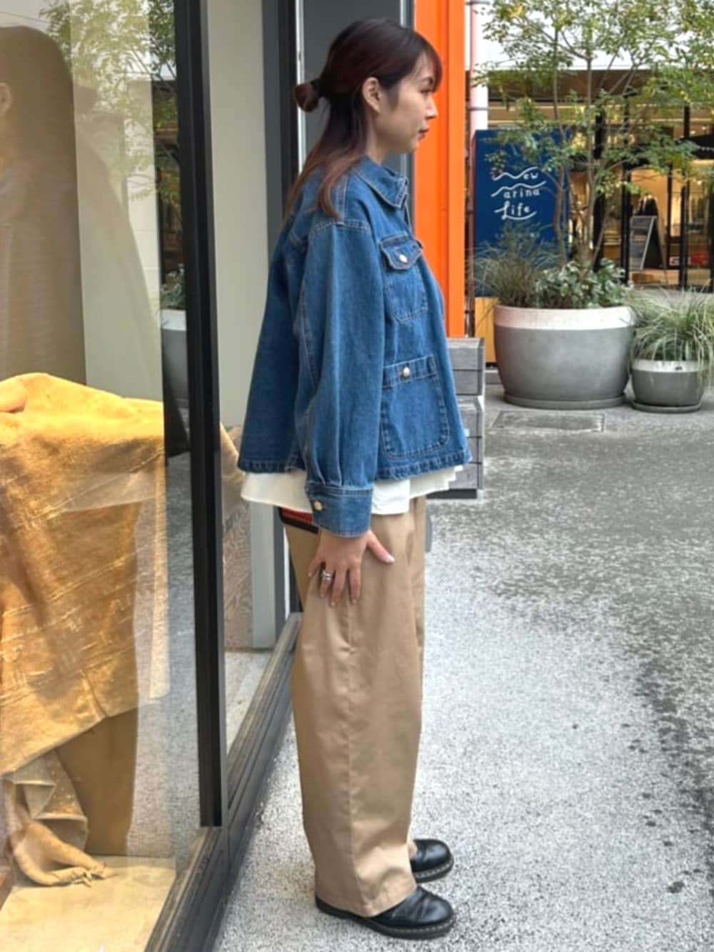 ブルー系のデニムジャケット、ベージュ系のチノパンツ、ベージュ系のTシャツ/カットソーを着用したレディースの春コーディネートの2枚目の写真