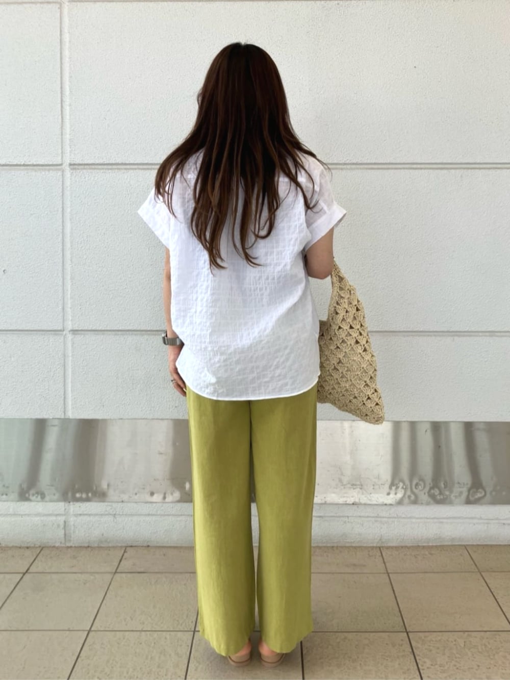 ブルー系のその他パンツ、ベージュ系のハンドバッグ、ホワイト系のシャツ/ブラウスを着用したレディースの夏コーディネートの3枚目の写真