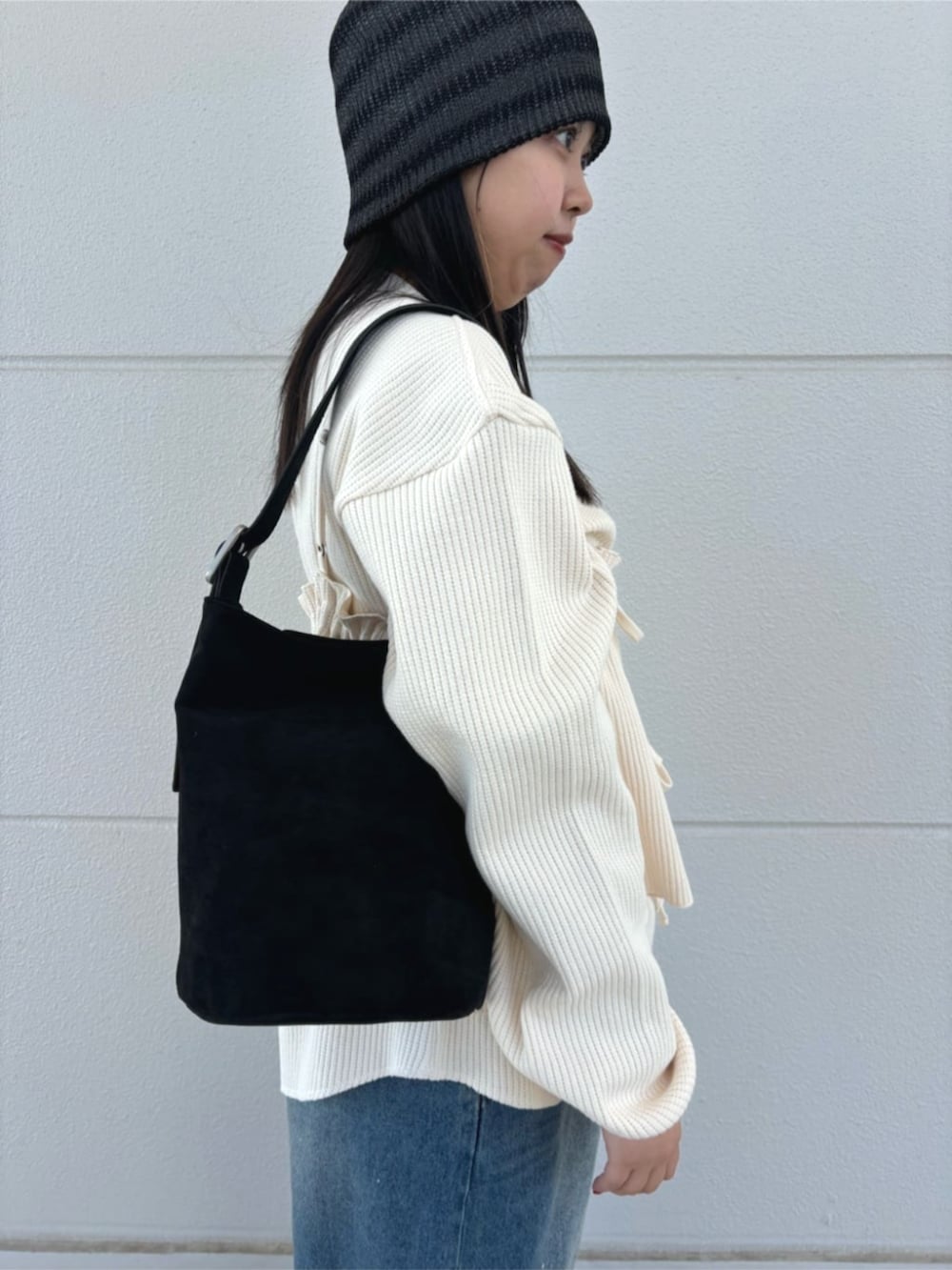 ブラック系のハンドバッグ、ブルー系のデニムパンツ、ホワイト系のTシャツ/カットソーを着用したレディースの春コーディネートの4枚目の写真