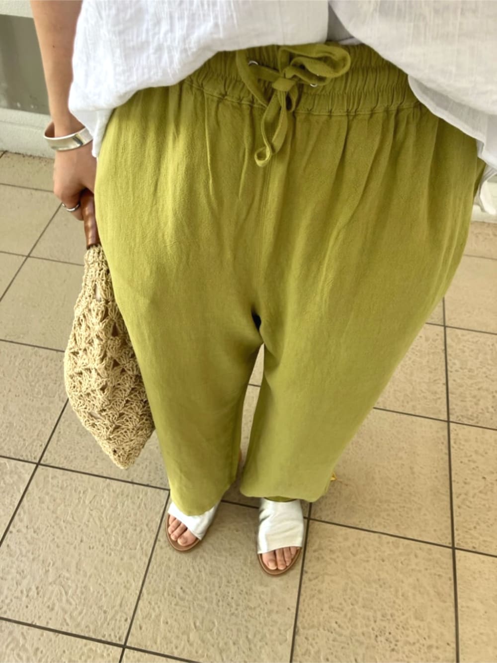 ブルー系のその他パンツ、ベージュ系のハンドバッグ、ホワイト系のシャツ/ブラウスを着用したレディースの夏コーディネートの5枚目の写真