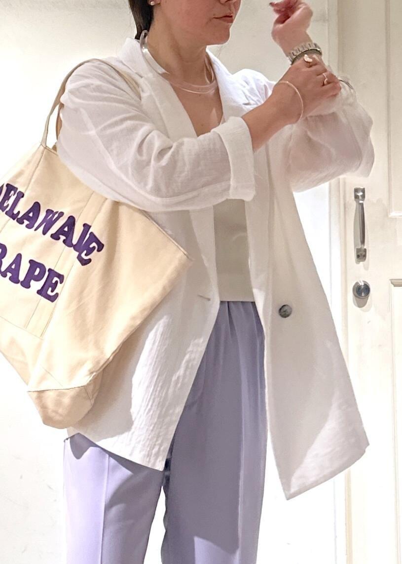 パープル系のスラックス、ホワイト系のテーラードジャケット、ホワイト系のスニーカーを着用したレディースの冬コーディネートの5枚目の写真