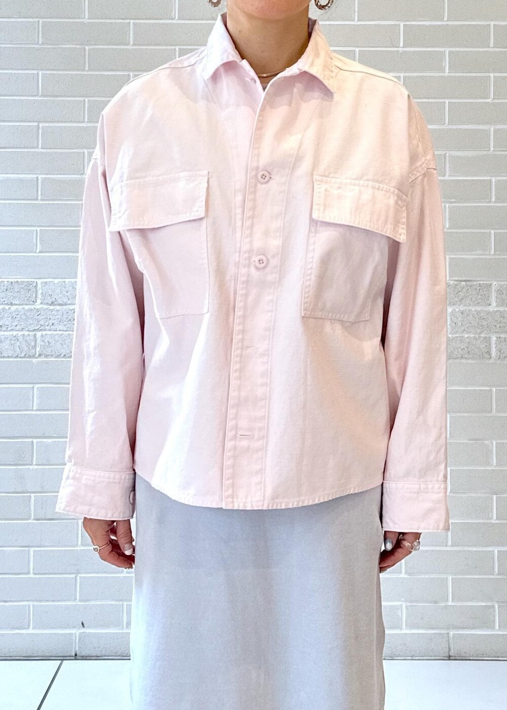 シルバー系のパンプス、グレー系のワンピース、グレー系のショルダーバッグを着用したレディースの冬コーディネートの5枚目の写真