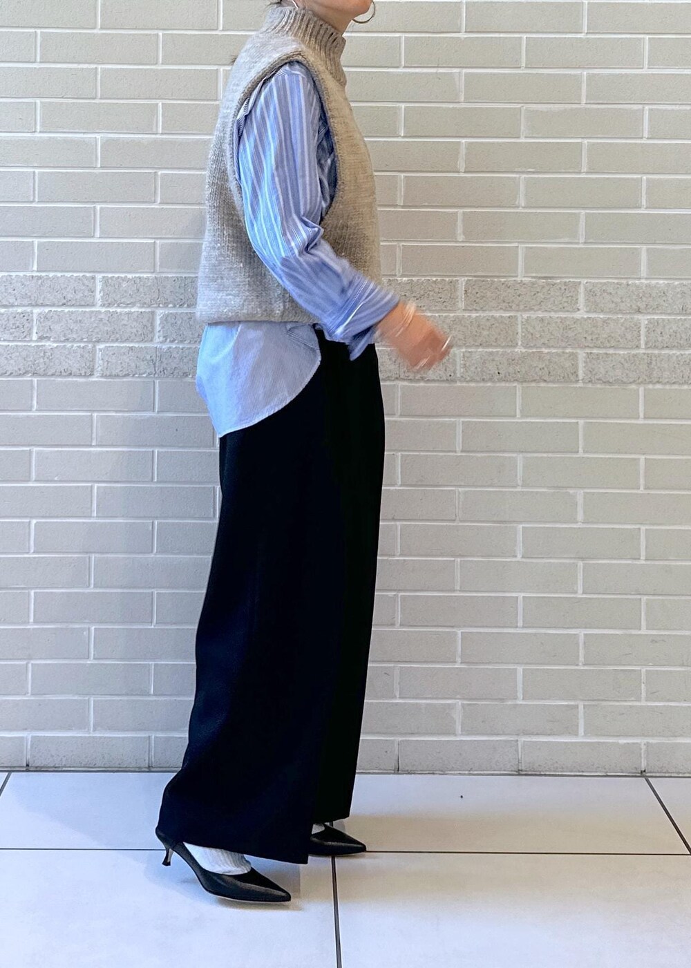 ブルー系のシャツ/ブラウス、ブラック系のスラックス、ブラック系のサンダルを着用したレディースの秋コーディネートの3枚目の写真