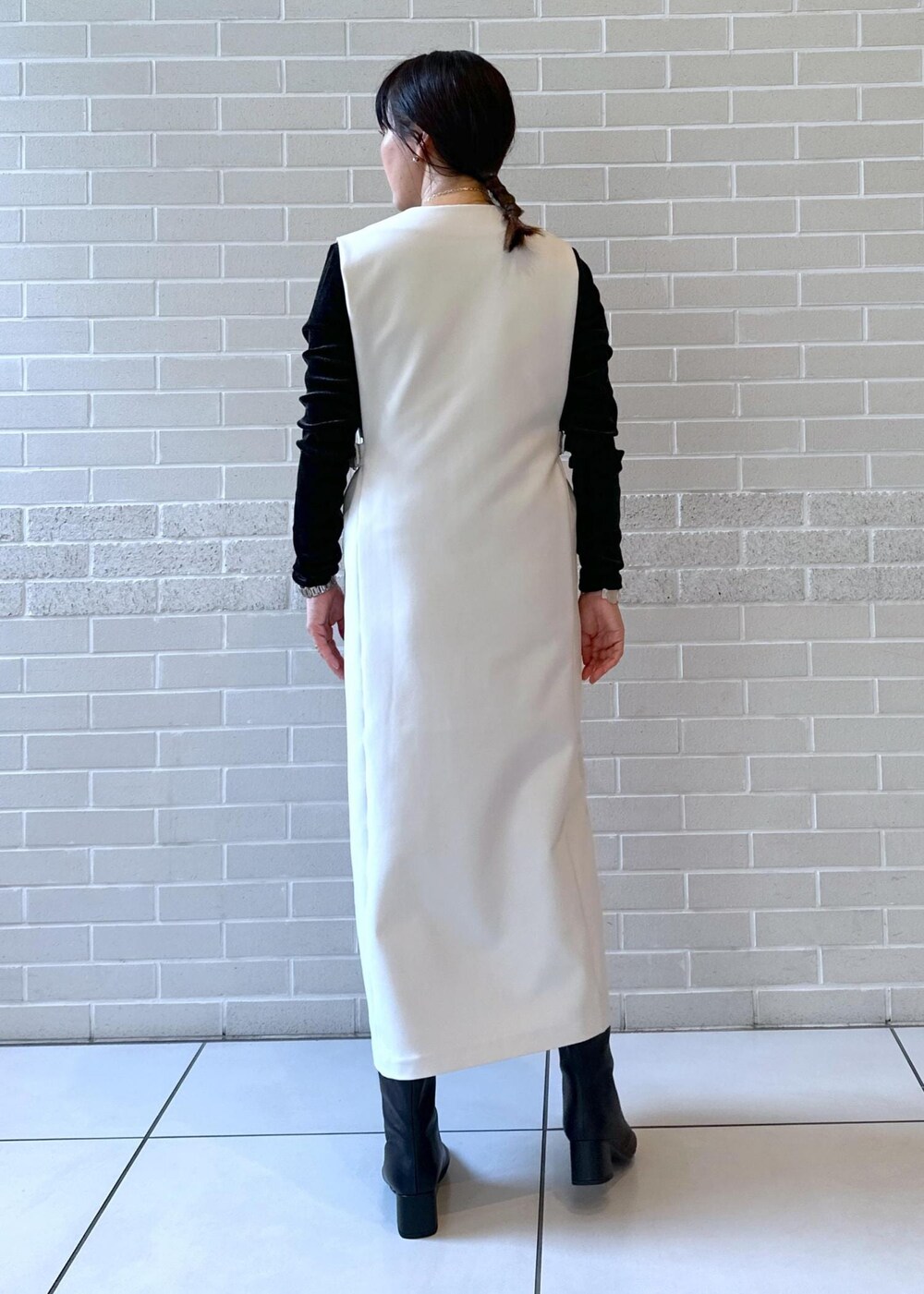 ブラック系のブーツ、ブラック系のジャンパースカート、ブラック系のTシャツ/カットソーを着用したレディースの秋コーディネートの3枚目の写真