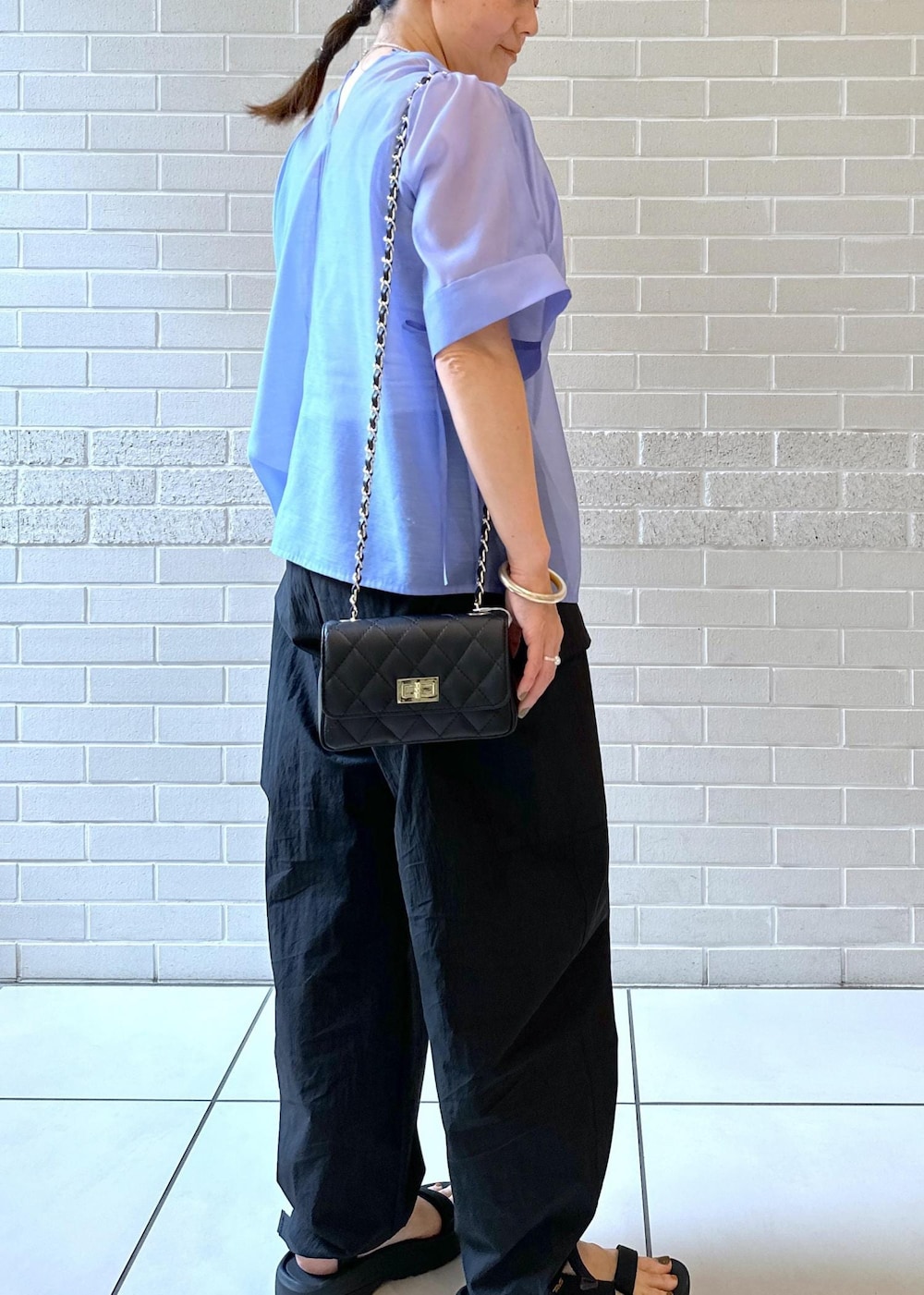 ブラック系のカーゴパンツ、ブラック系のサンダル、ブルー系のシャツ/ブラウスを着用したレディースの夏コーディネートの3枚目の写真