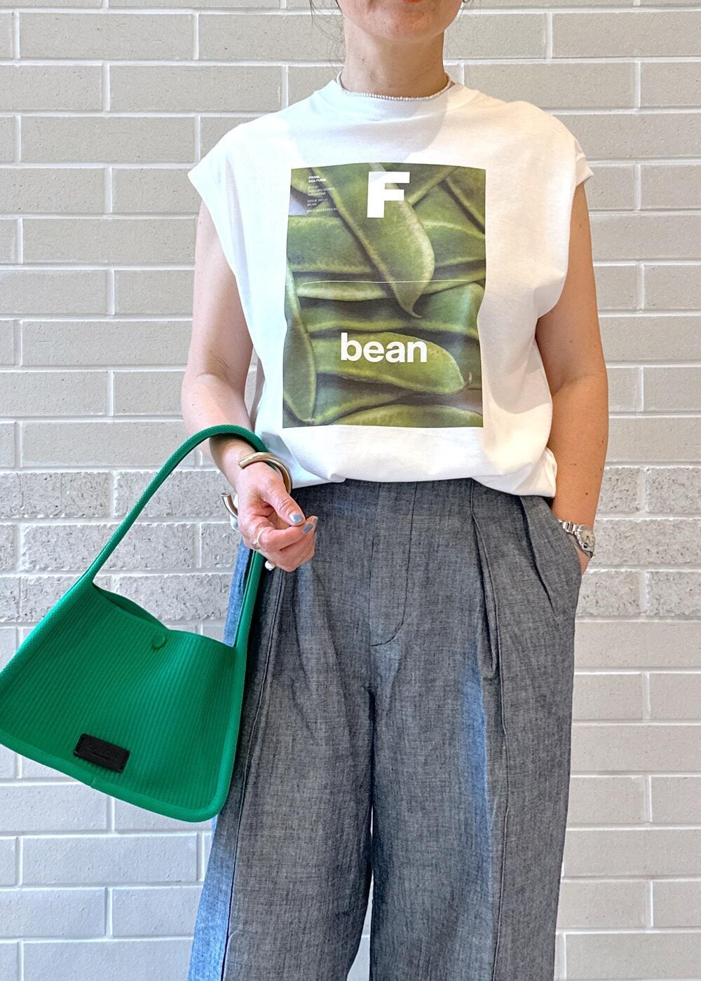 ホワイト系のTシャツ/カットソー、ブラック系のサンダル、グリーン系のハンドバッグを着用したレディースの夏コーディネートの3枚目の写真