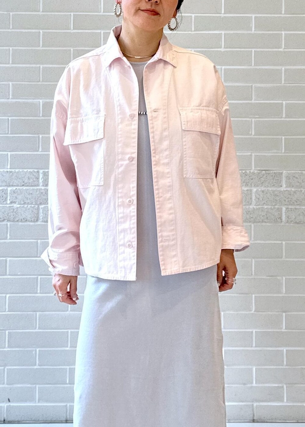 シルバー系のパンプス、グレー系のワンピース、グレー系のショルダーバッグを着用したレディースの冬コーディネートの4枚目の写真