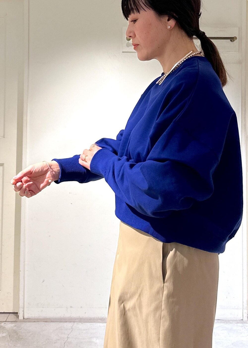 ブルー系のスウェット、ベージュ系のスカート、ブラック系のサンダルを着用したレディースの冬コーディネートの4枚目の写真