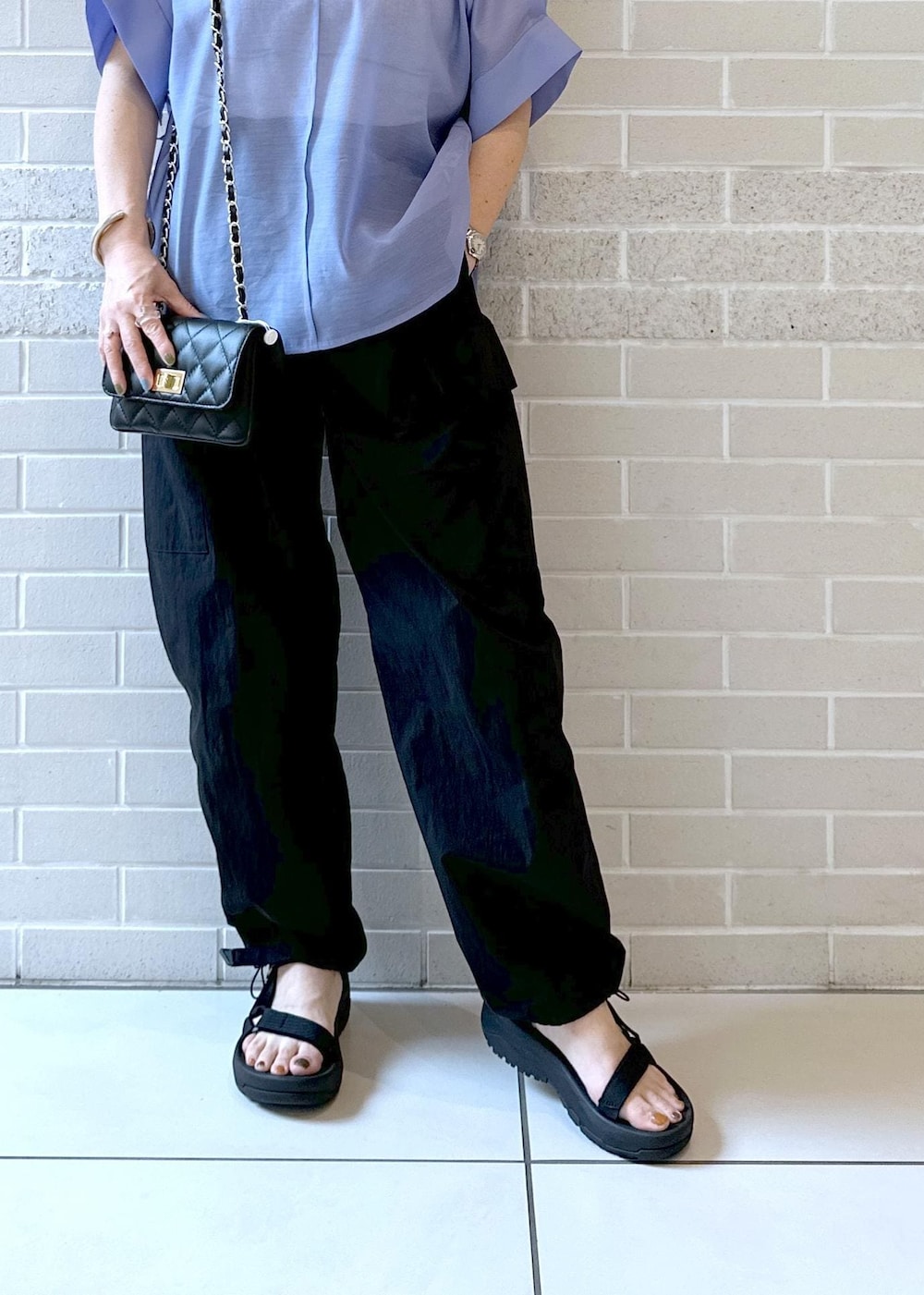 ブラック系のカーゴパンツ、ブラック系のサンダル、ブルー系のシャツ/ブラウスを着用したレディースの夏コーディネートの6枚目の写真