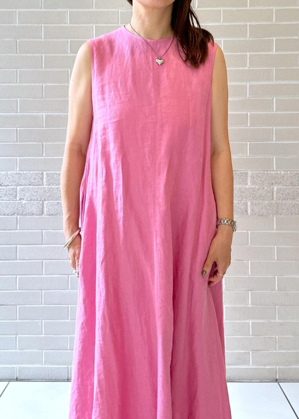 グレー系のブーツ、ピンク系のワンピース、ホワイト系のシャツ/ブラウスを着用したレディースの夏コーディネートの3枚目の写真