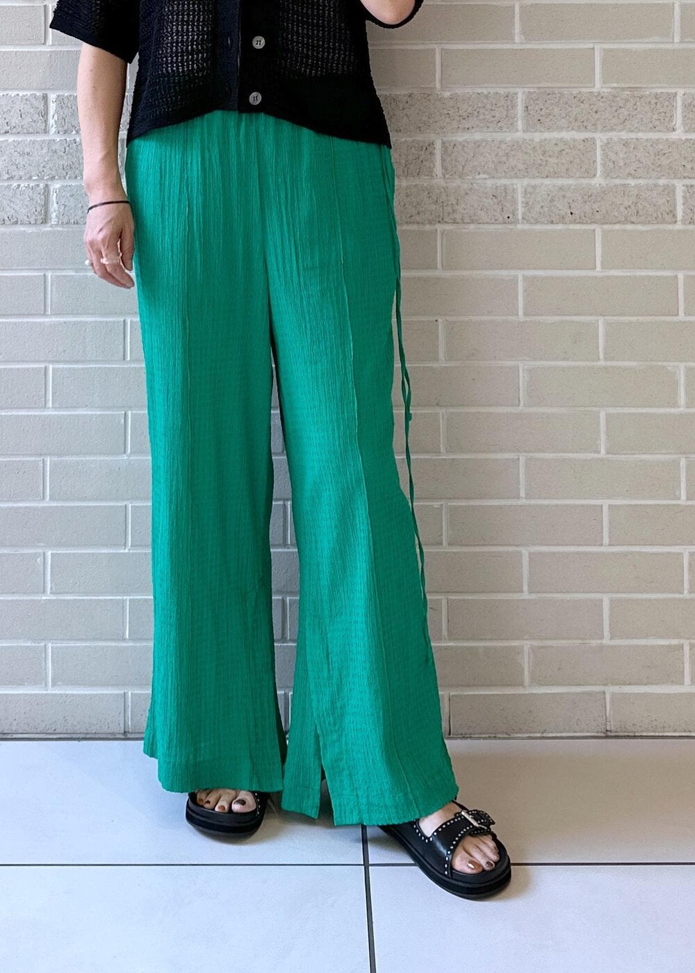 ブラック系のサンダル、グレー系のタンクトップ、ブラック系のカーディガン/ボレロを着用したレディースの夏コーディネートの5枚目の写真