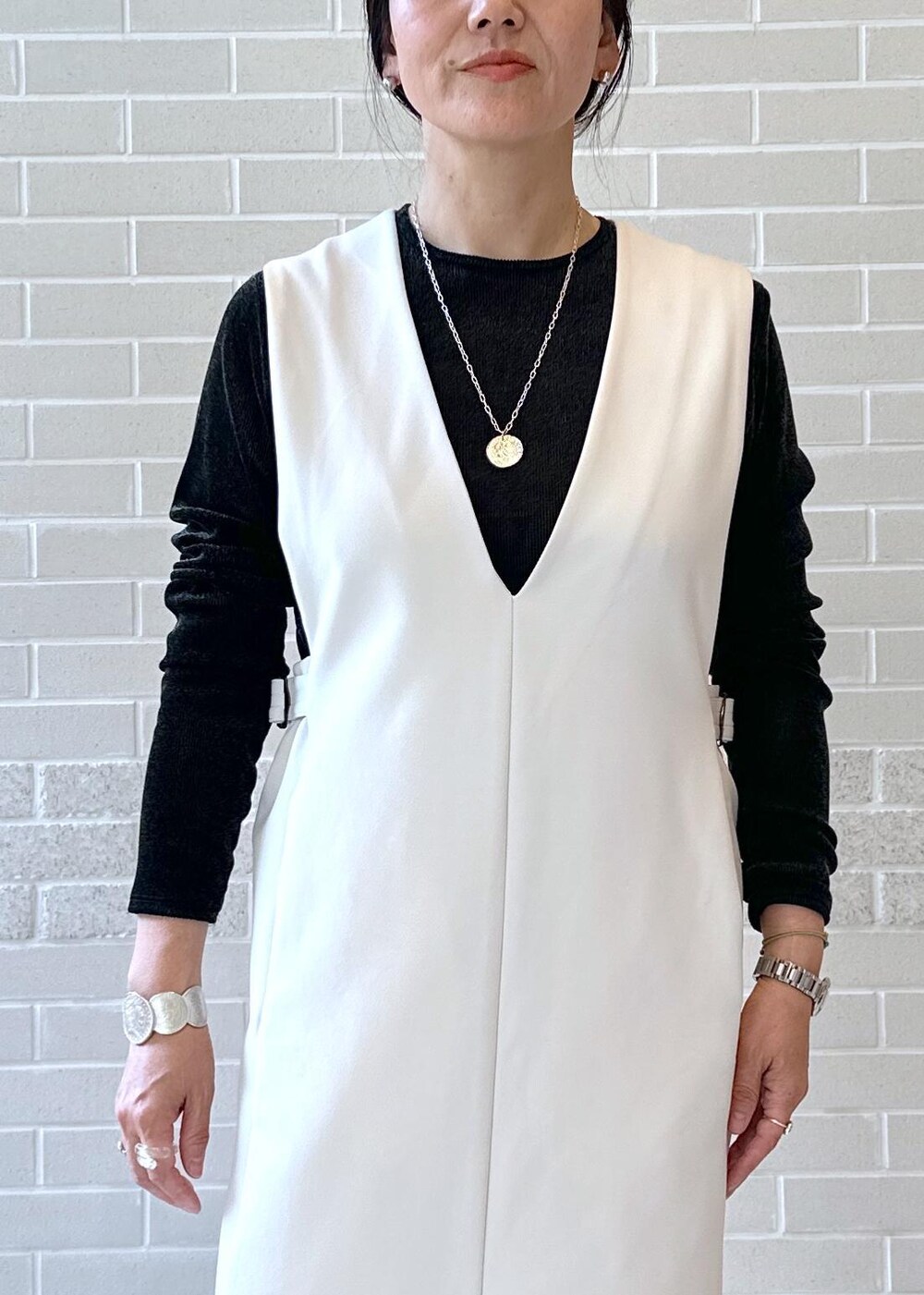 ブラック系のブーツ、ブラック系のジャンパースカート、ブラック系のTシャツ/カットソーを着用したレディースの秋コーディネートの4枚目の写真