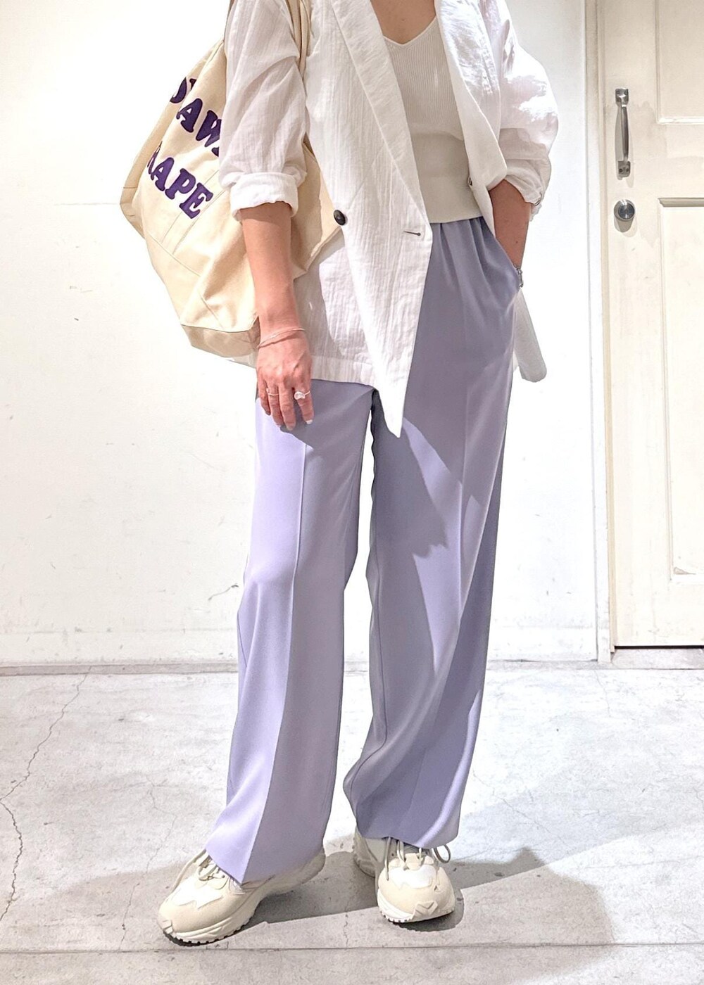 パープル系のスラックス、ホワイト系のテーラードジャケット、ホワイト系のスニーカーを着用したレディースの冬コーディネートの6枚目の写真