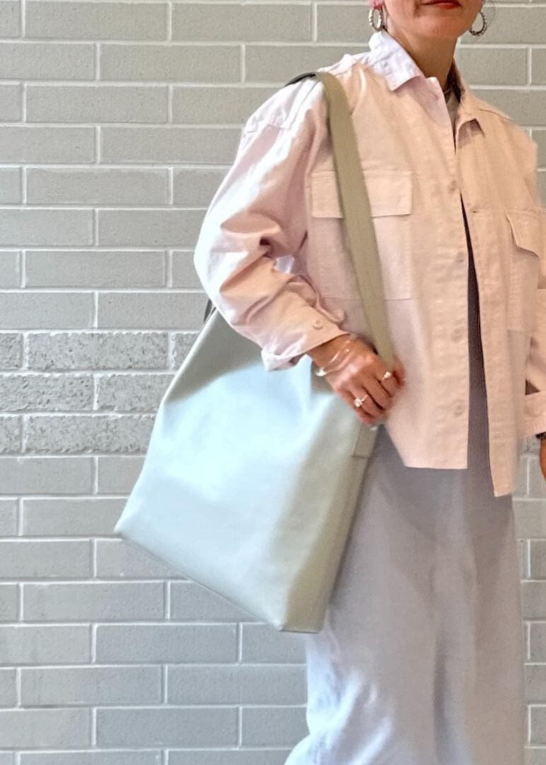 シルバー系のパンプス、グレー系のワンピース、グレー系のショルダーバッグを着用したレディースの冬コーディネートの7枚目の写真