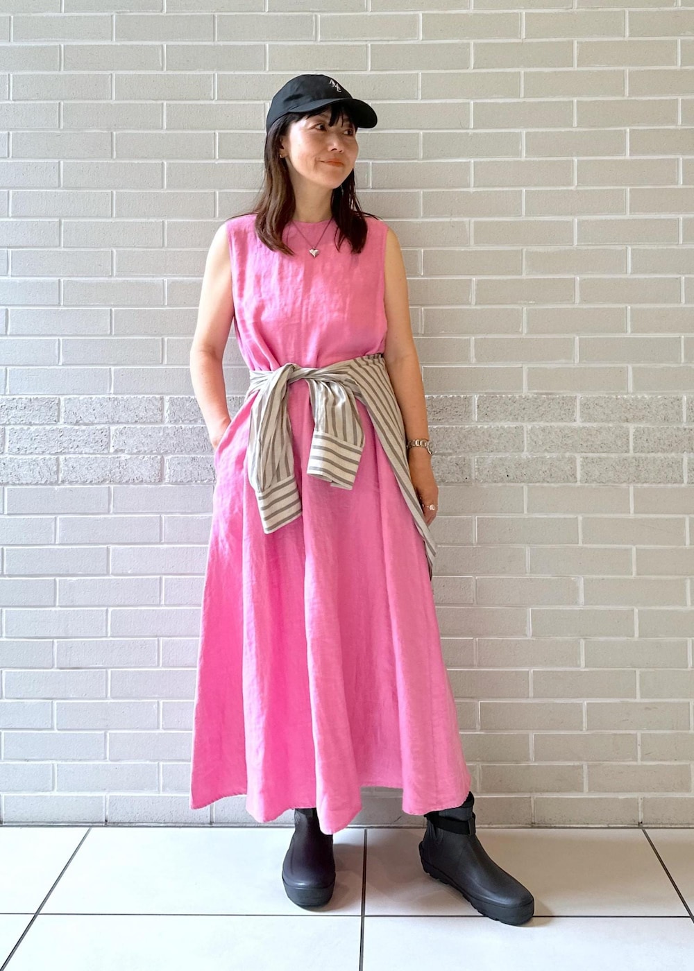 グレー系のブーツ、ピンク系のワンピース、ホワイト系のシャツ/ブラウスを着用したレディースの夏コーディネートの2枚目の写真