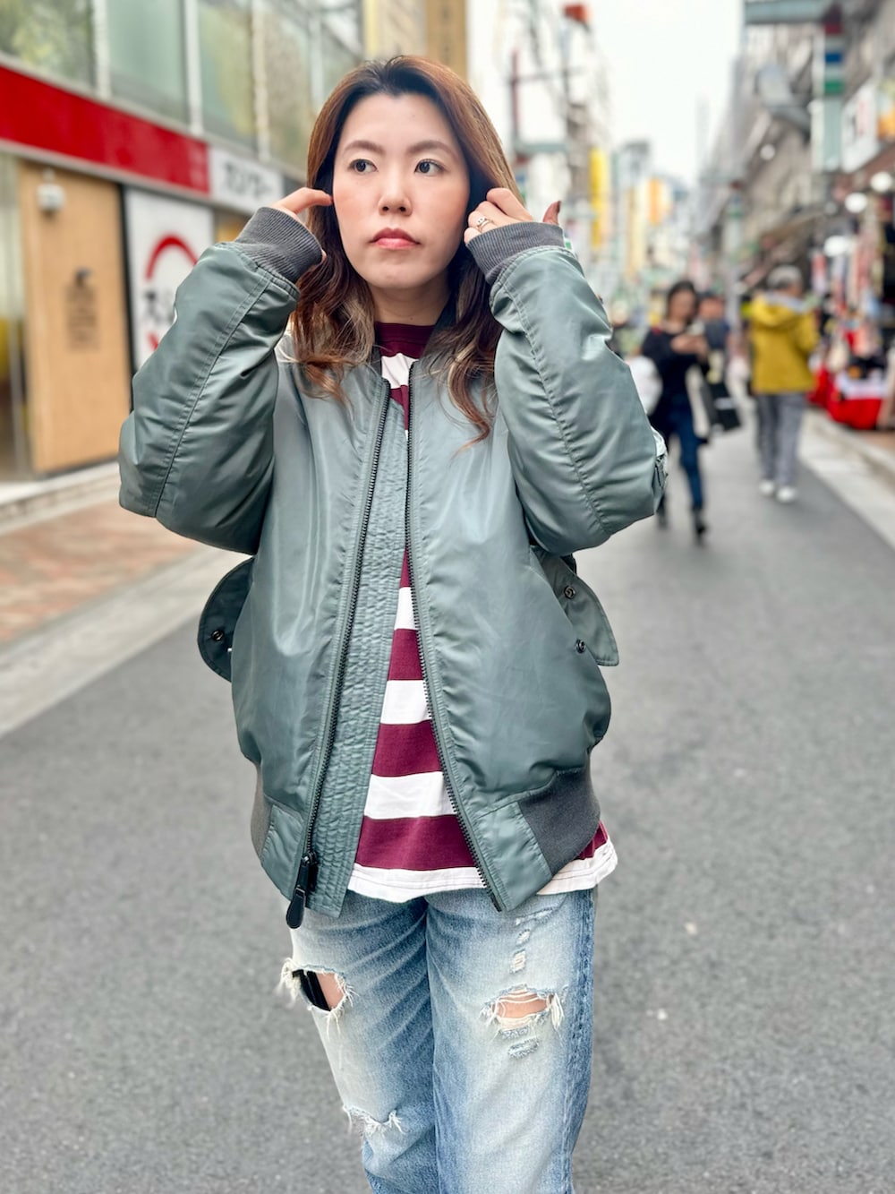 グリーン系のMA-1、レッド系のTシャツ/カットソーを着用したレディースの秋コーディネートの2枚目の写真