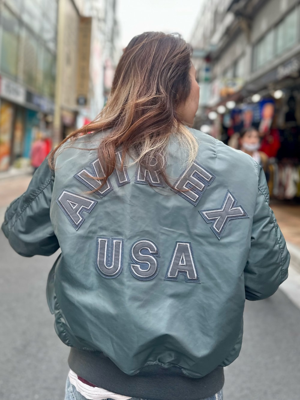 グリーン系のMA-1、レッド系のTシャツ/カットソーを着用したレディースの秋コーディネートの5枚目の写真