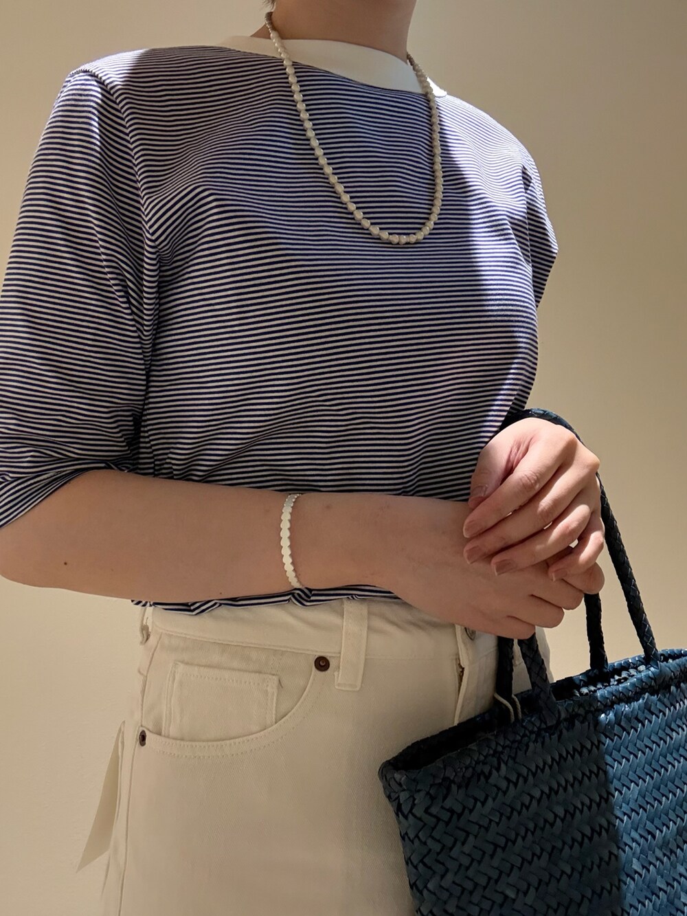 ブルー系のTシャツ/カットソー、ホワイト系のデニムパンツ、ブルー系のトートバッグを着用したレディースの夏コーディネートの5枚目の写真