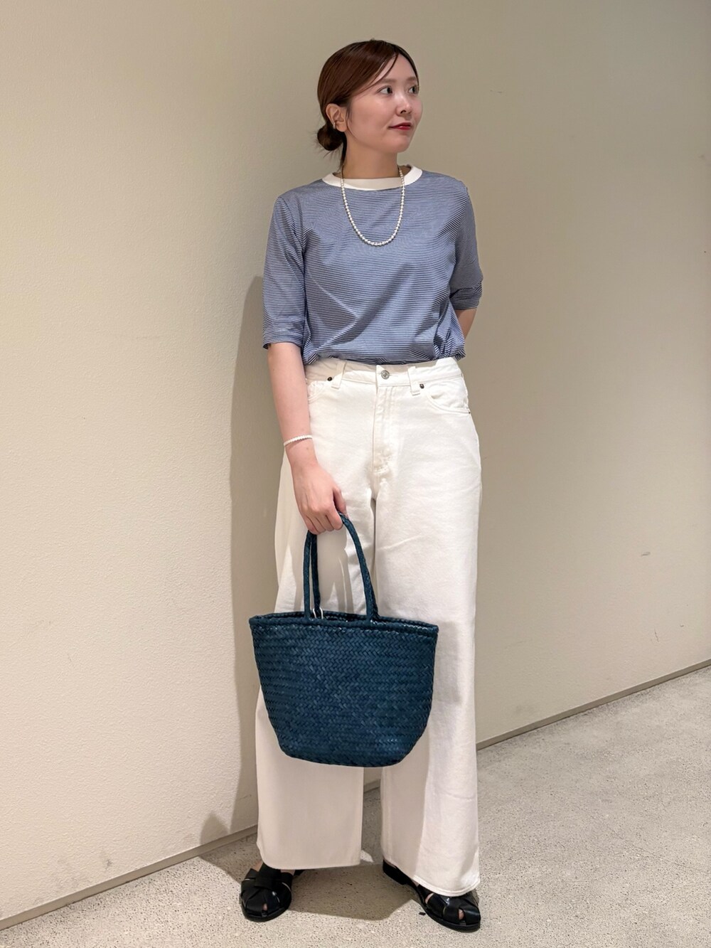 ブルー系のTシャツ/カットソー、ホワイト系のデニムパンツ、ブルー系のトートバッグを着用したレディースの夏コーディネートの2枚目の写真