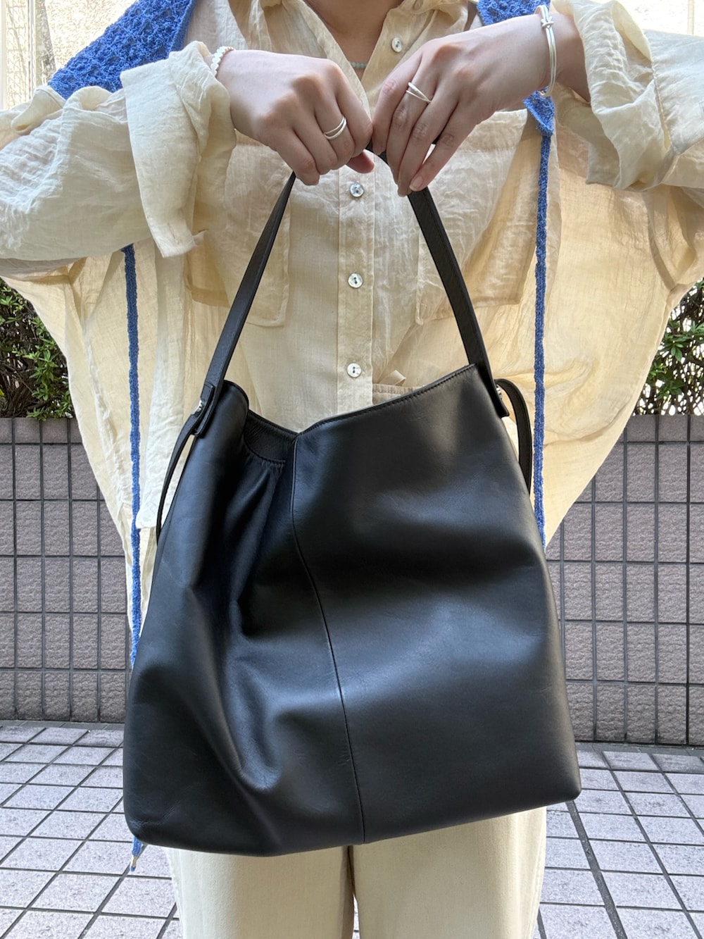 ベージュ系のシャツ/ブラウス、ブラック系のトートバッグ、ベージュ系のその他パンツを着用したレディースの夏コーディネートの8枚目の写真