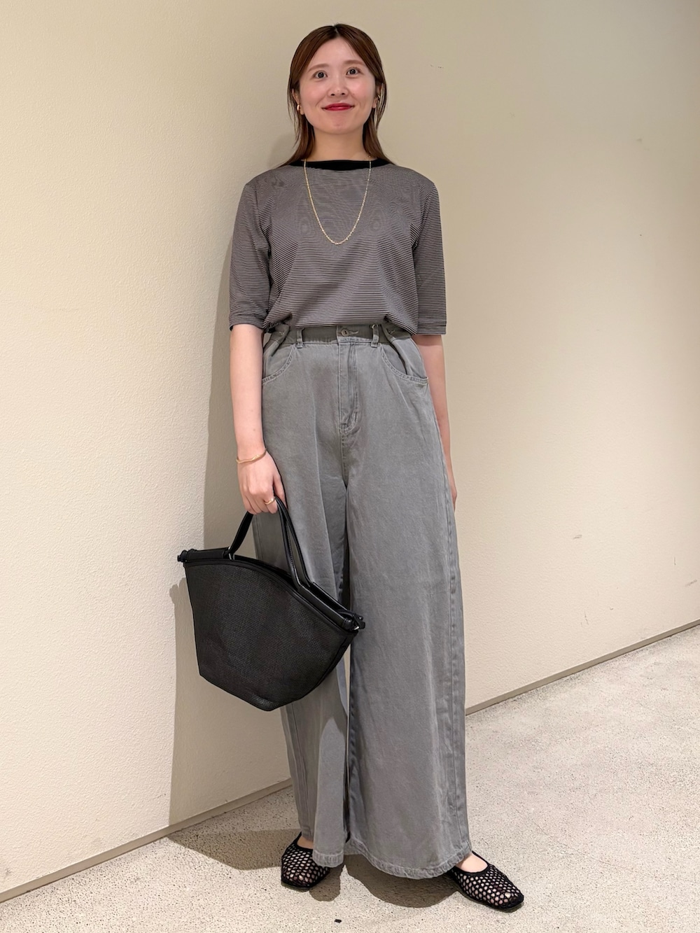 グレー系のTシャツ/カットソー、グレー系のデニムパンツ、ゴールド系のネックレスを着用したレディースの夏コーディネートの2枚目の写真