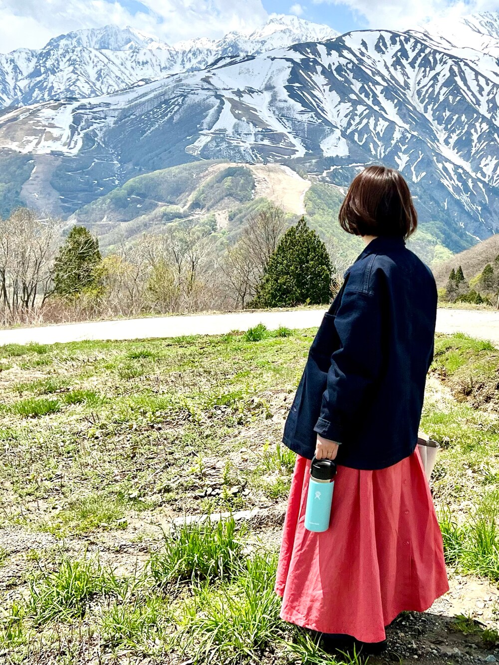 ブルー系のジャケット/アウター、オレンジ系のワンピースを着用したレディースの春コーディネートの2枚目の写真