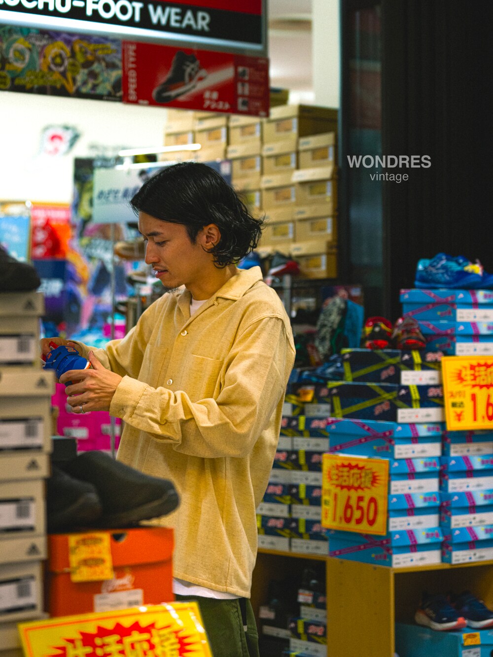 グリーン系のカーゴパンツ、ベージュ系のシャツ/ブラウス、ブラック系のスニーカーを着用したメンズの秋コーディネートの4枚目の写真