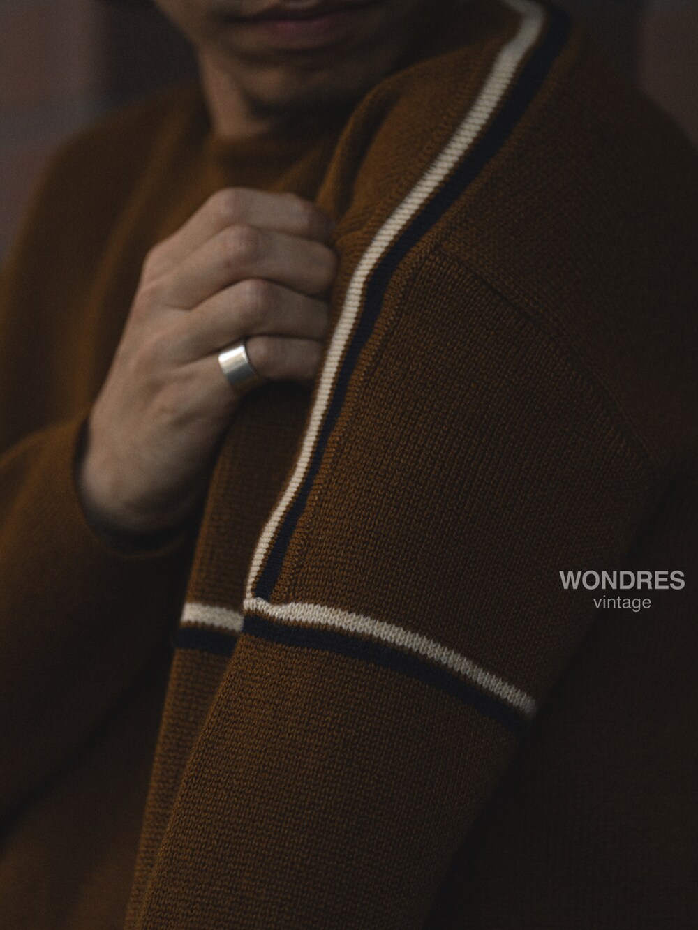 ブラウン系のニット/セーター、ブラック系のデニムパンツ、ブラック系のスニーカーを着用したメンズの秋コーディネートの3枚目の写真