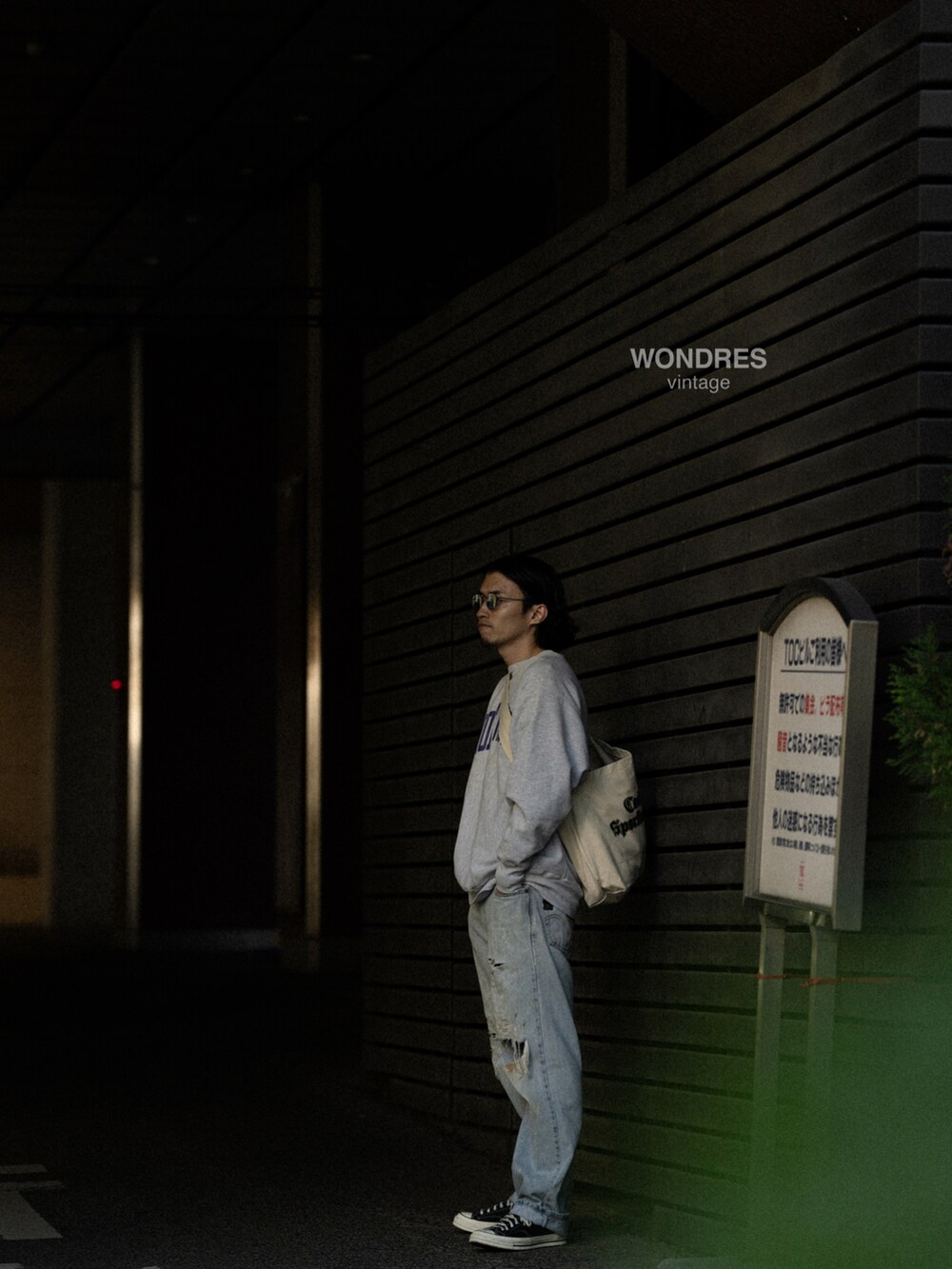 ブルー系のデニムパンツ、シルバー系のスウェット、ベージュ系のメッセンジャーバッグを着用したメンズの秋コーディネートの2枚目の写真