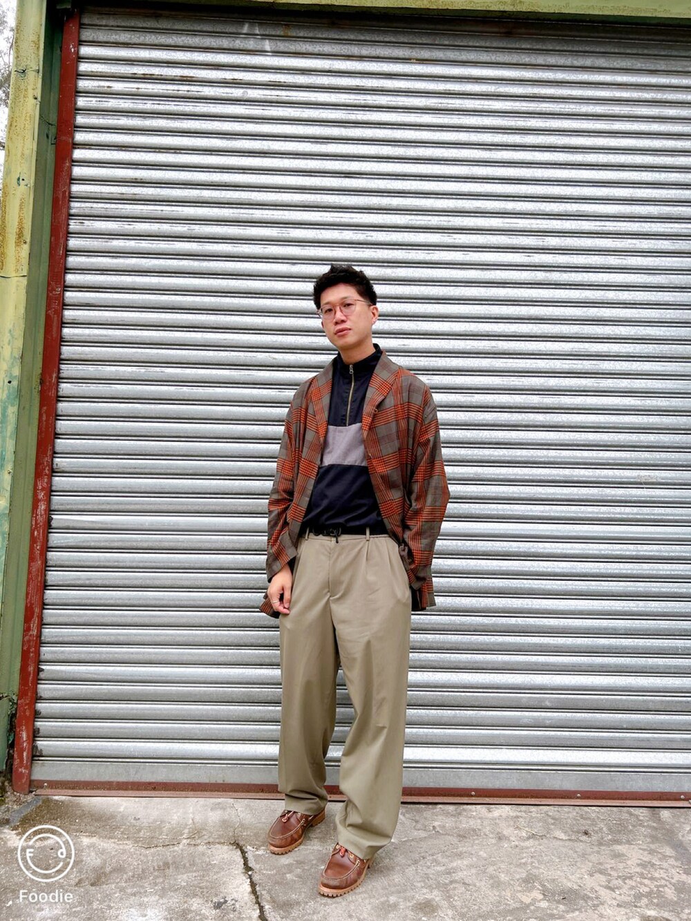 グリーン系のパンツ、オレンジ系のシャツ/ブラウス、ブラウン系のモカシン/デッキシューズを着用したメンズの春コーディネートの2枚目の写真