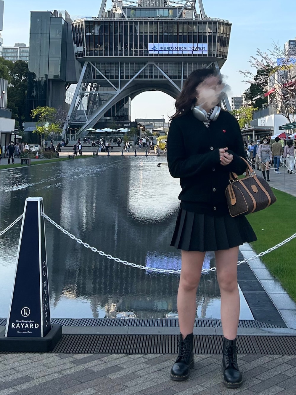 ブラウン系のボストンバッグ、ブラック系のカーディガン/ボレロ、ブラック系のスカートを着用したレディースの春コーディネートの2枚目の写真