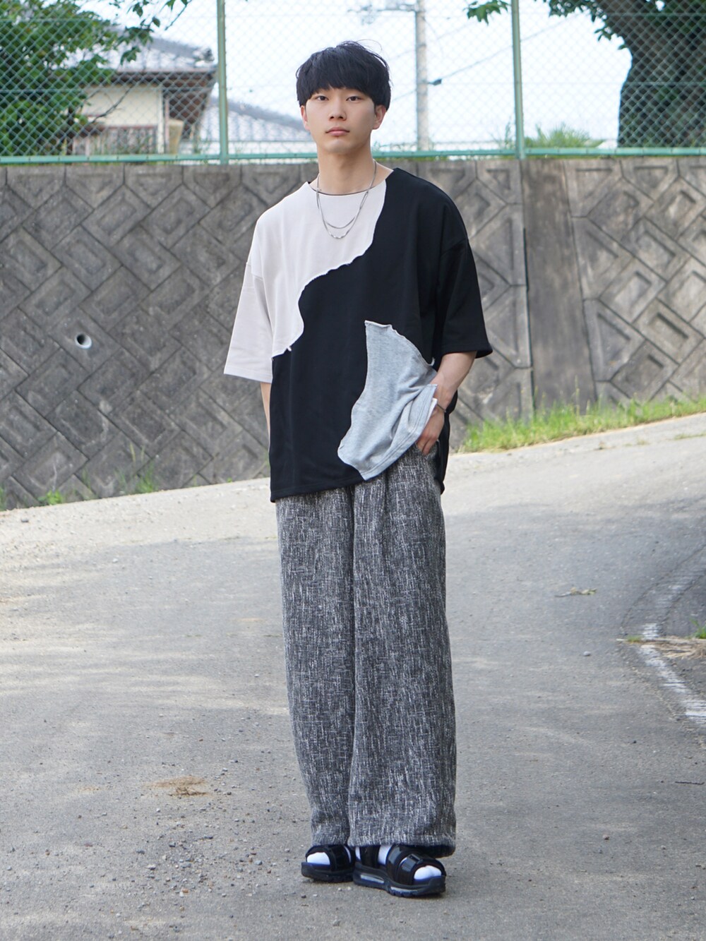 ブラック系のTシャツ/カットソー、ブラック系のその他パンツ、ホワイト系のサンダルを着用したメンズの夏コーディネートの2枚目の写真