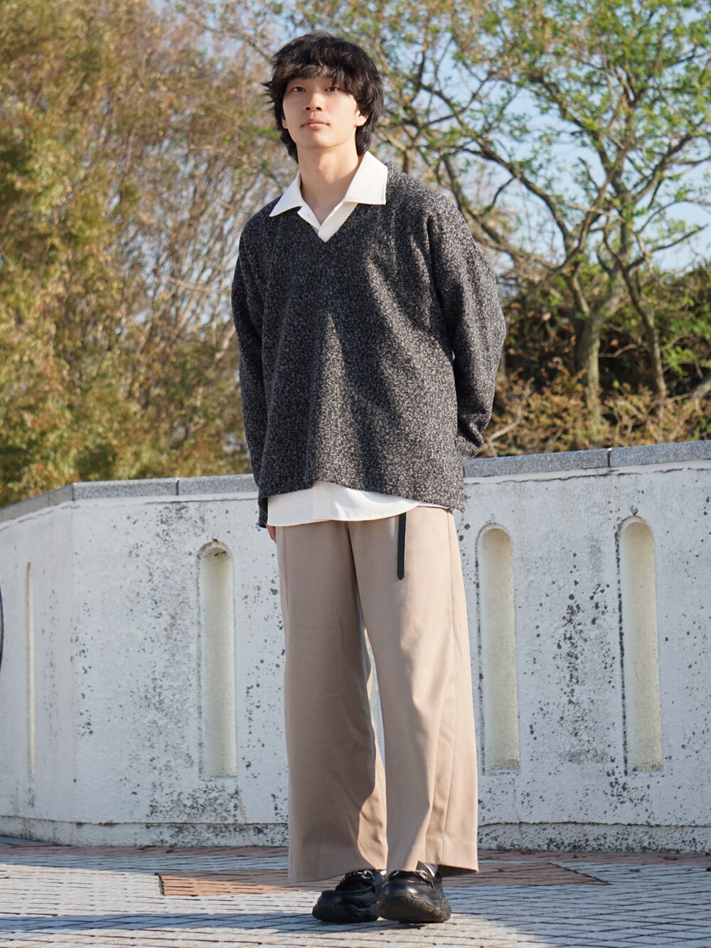 ブラック系のスウェット、ホワイト系のシャツ/ブラウス、ベージュ系のスラックスを着用したメンズの秋コーディネートの2枚目の写真