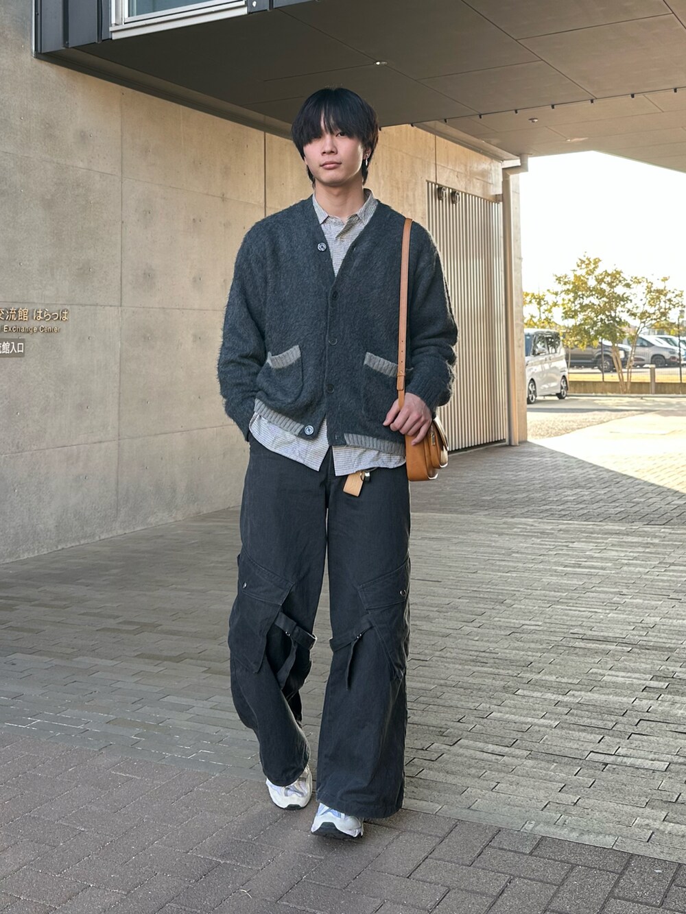 グレー系のカーディガン/ボレロ、ブラック系のカーゴパンツ、ホワイト系のスニーカーを着用したメンズの冬コーディネートの3枚目の写真