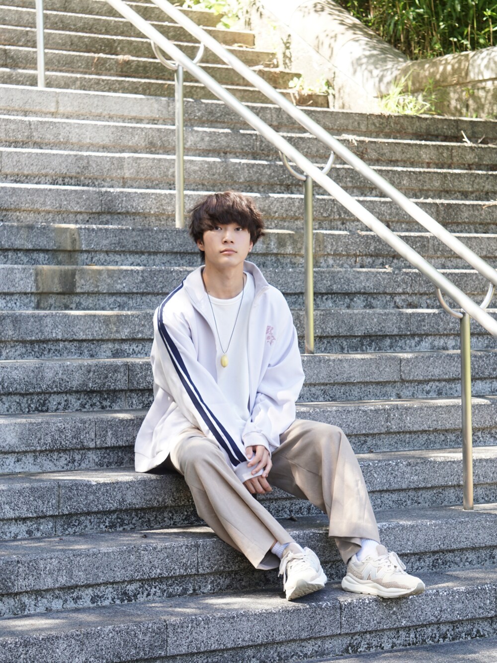 ホワイト系のジャケット/アウター、ホワイト系のTシャツ/カットソー、ベージュ系のスラックスを着用したメンズの秋コーディネートの2枚目の写真