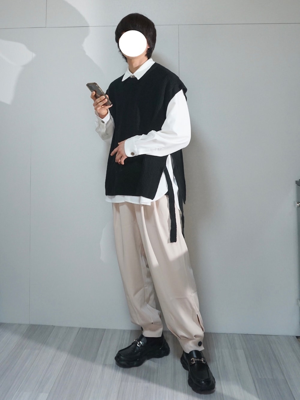 ブラック系のスニーカー、ベージュ系のその他パンツ、ブラック系のベストを着用したメンズの春コーディネートの2枚目の写真
