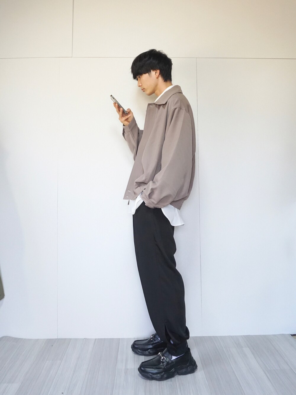 ベージュ系のブルゾン、ホワイト系のシャツ/ブラウス、ブラック系のその他パンツを着用したメンズの秋コーディネートの2枚目の写真