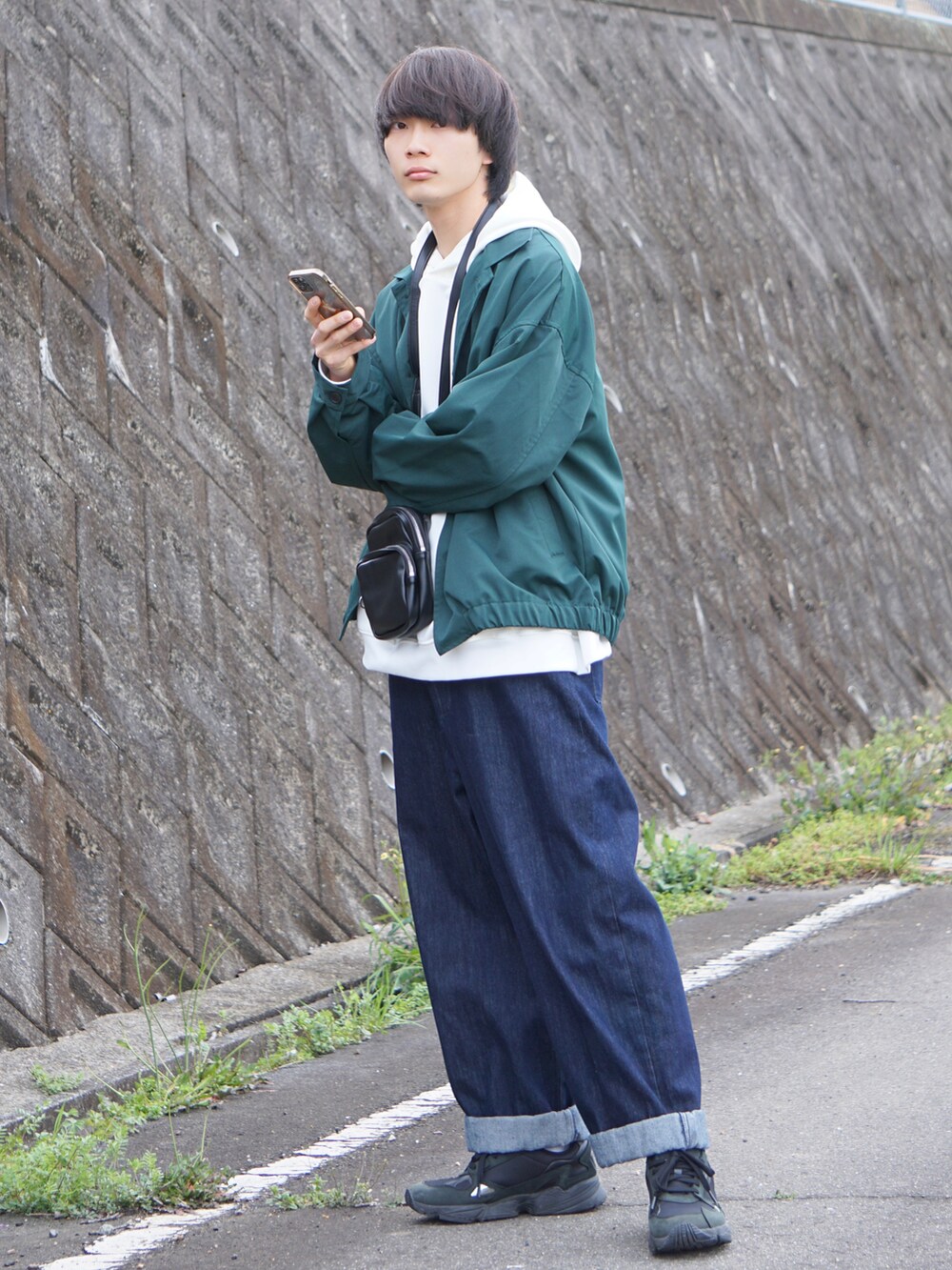 ブルー系のデニムパンツ、ブラック系のスニーカー、グリーン系のその他アウターを着用したメンズの春コーディネートの2枚目の写真