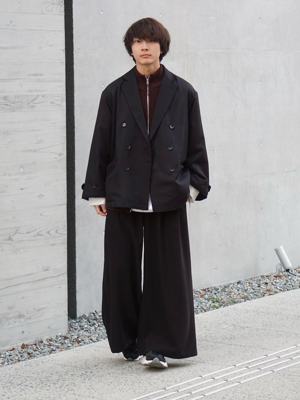 ブラック系のスラックス、ブラック系のテーラードジャケット、ブラウン系のカーディガン/ボレロを着用したメンズの冬コーディネートの2枚目の写真