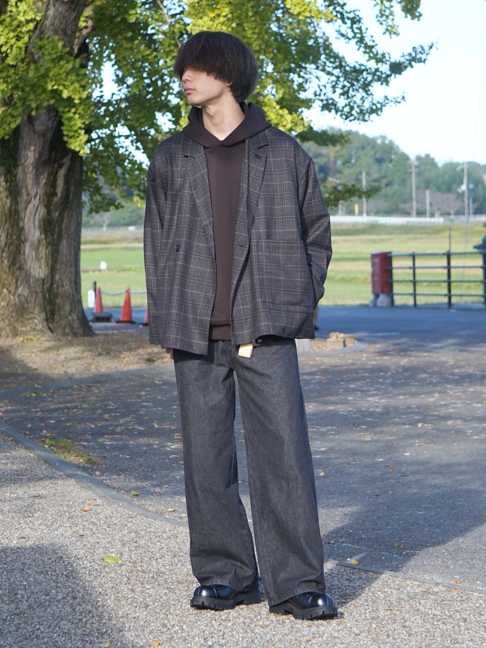 ブラック系のテーラードジャケット、ブラック系のデニムパンツ、ブラック系のローファーを着用したメンズの秋コーディネートの2枚目の写真