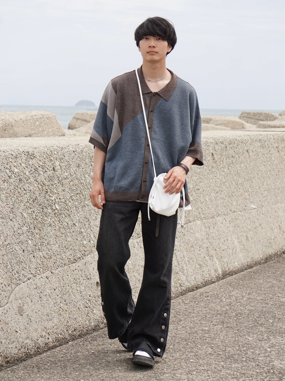 ブラック系のデニムパンツ、ブラウン系のシャツ/ブラウス、ホワイト系のショルダーバッグを着用したメンズの春コーディネートの3枚目の写真