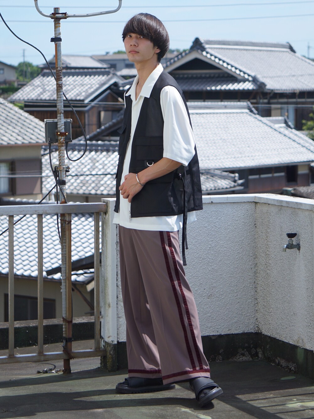 ブラック系のサンダル、ブラウン系のその他パンツ、ブラック系のベストを着用したメンズの夏コーディネートの2枚目の写真