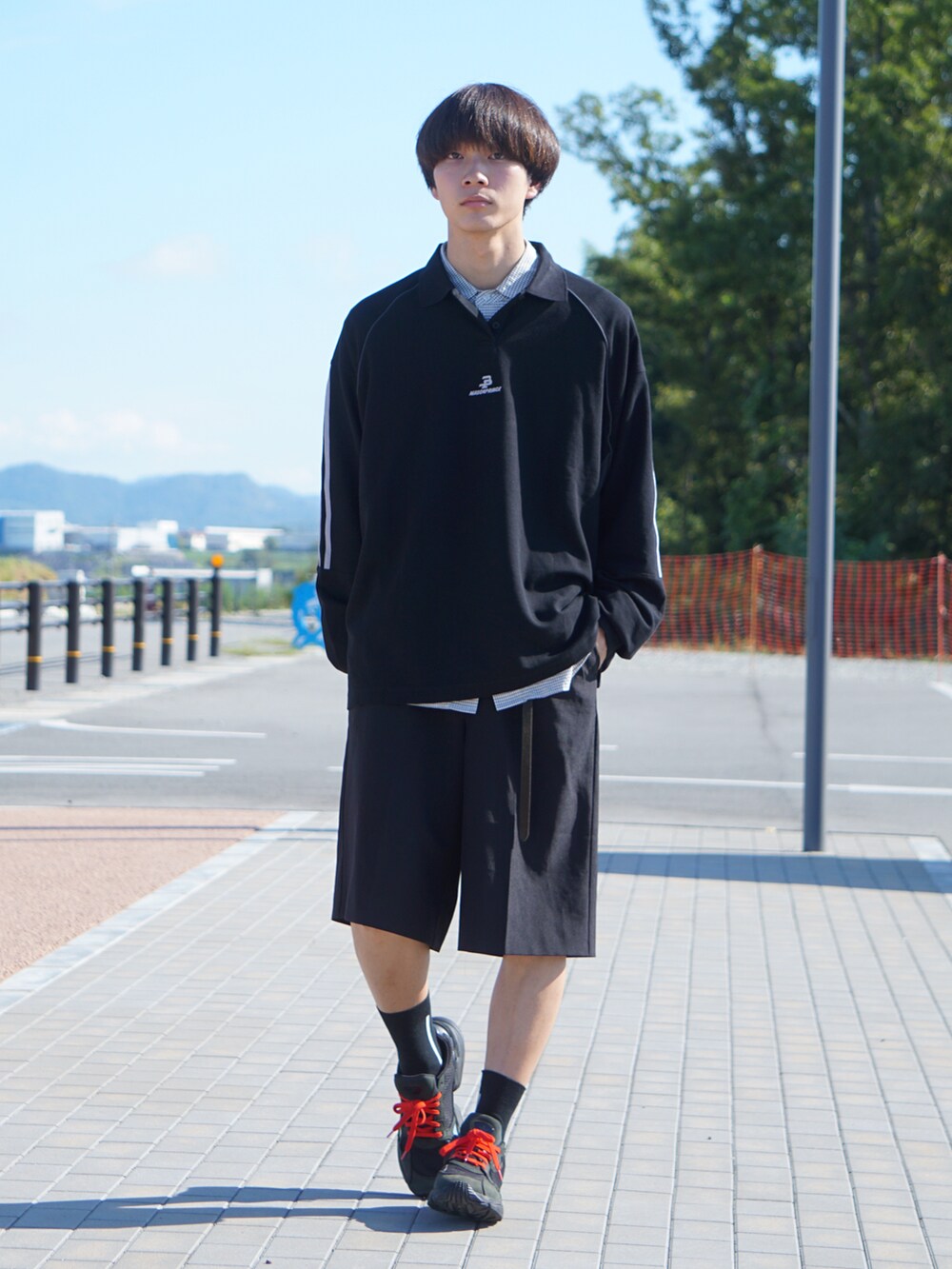 ブラック系のポロシャツ、ブラック系のスニーカー、ホワイト系のシャツ/ブラウスを着用したメンズの秋コーディネートの2枚目の写真