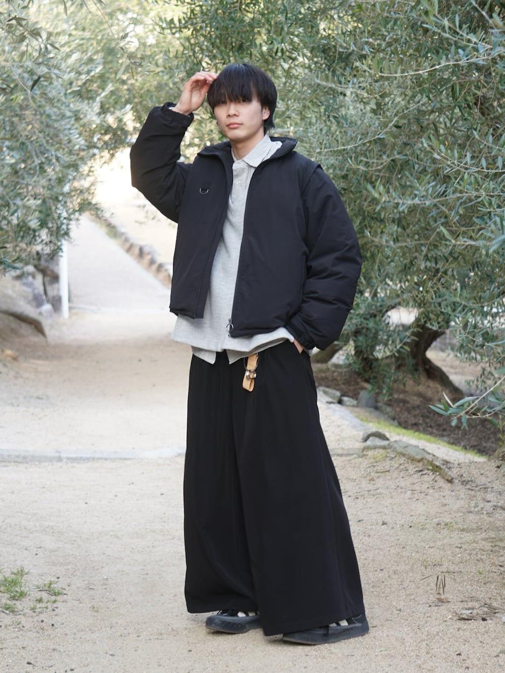 ブラック系のブルゾン、ブラック系のスラックス、ホワイト系のシャツ/ブラウスを着用したメンズの冬コーディネートの2枚目の写真