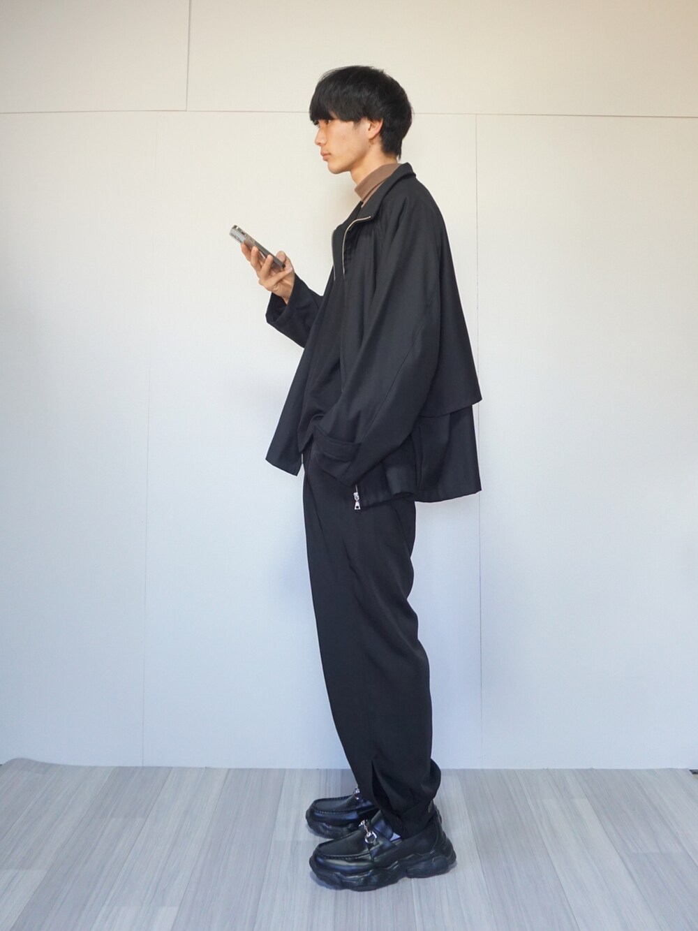 ブラック系のブルゾン、ブラック系のTシャツ/カットソー、ブラック系のその他パンツを着用したメンズの秋コーディネートの2枚目の写真