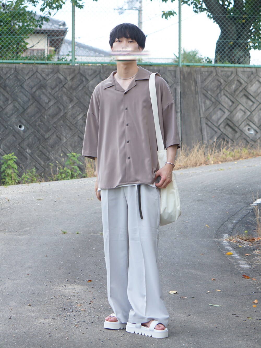 グレー系のスラックス、ブラウン系のシャツ/ブラウス、ホワイト系のサンダルを着用したメンズの夏コーディネートの2枚目の写真
