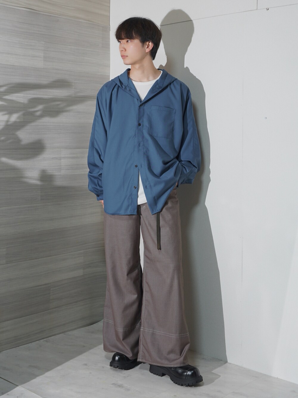 ベージュ系のスラックス、ブラック系のローファー、ブルー系のパーカーを着用したメンズの春コーディネートの2枚目の写真