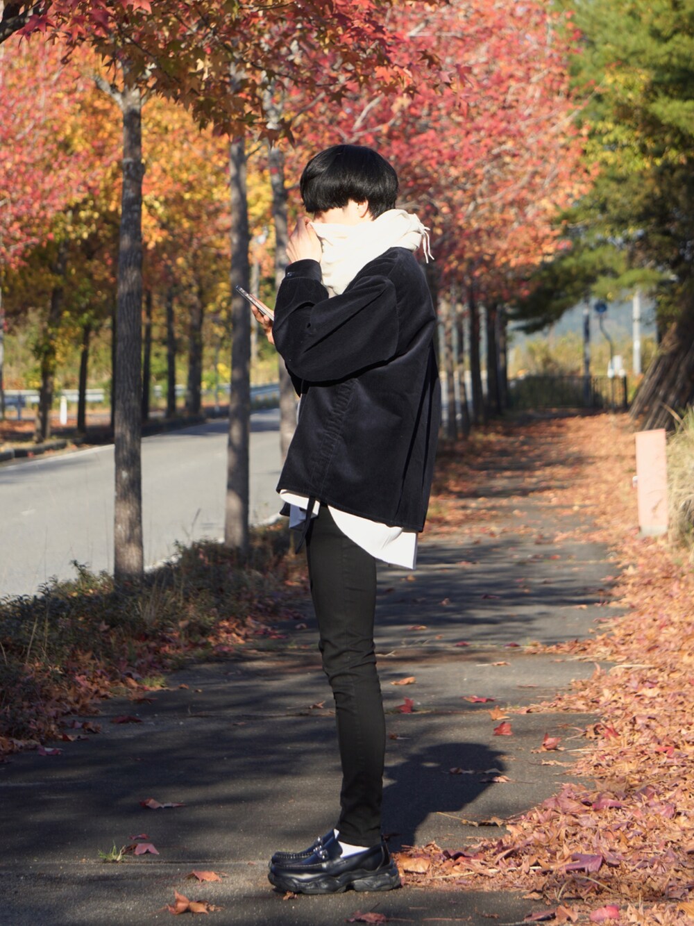 ブラック系のスニーカー、ブルー系のブルゾン、ブラック系のデニムパンツを着用したメンズの秋コーディネートの2枚目の写真