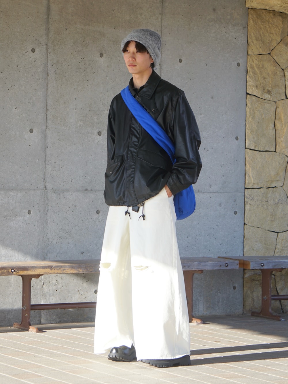 ブラック系のブルゾン、ホワイト系のデニムパンツ、ブラック系のローファーを着用したメンズの冬コーディネートの2枚目の写真